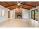 Open living room showcases a stunning wood ceiling, cozy brick fireplace, and bright natural light at 8410 Lake Bosse Dr, Orlando, FL 32810