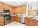 Well-lit kitchen featuring stainless steel appliances, light countertops, and ample wood cabinetry at 866 Ashworth Overlook Dr # B, Apopka, FL 32712
