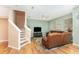 Cozy living room with hardwood floors, stairs, and comfortable leather seating at 866 Ashworth Overlook Dr # B, Apopka, FL 32712