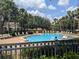 The community pool is surrounded by chairs, trees and landscaping at 866 Ashworth Overlook Dr # B, Apopka, FL 32712