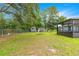 Spacious backyard with a shed, screened-in patio, and fire pit providing a great outdoor living area at 8869 Se 159Th Pl, Summerfield, FL 34491