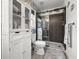 Clean bathroom showcasing a glass shower, a linen cabinet, and floral wallpaper at 8869 Se 159Th Pl, Summerfield, FL 34491