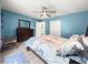 Comfortable bedroom featuring a wooden dresser, ceiling fan, and soft blue walls at 8869 Se 159Th Pl, Summerfield, FL 34491