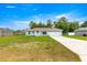 Single-story home with a well-maintained lawn and a driveway leading to an attached two-car garage at 8869 Se 159Th Pl, Summerfield, FL 34491
