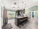 Modern kitchen with stainless steel appliances, an island with bar stools, and ample natural light at 8869 Se 159Th Pl, Summerfield, FL 34491