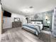 Spacious main bedroom featuring an accent wall, gray wood-look flooring and a dresser with mirror at 8869 Se 159Th Pl, Summerfield, FL 34491