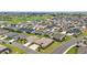 An aerial view shows the landscape with well-manicured lawns, houses and a golf course in the distance at 892 Hubbard Loop, The Villages, FL 32163