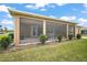 Exterior view of screened lanai with well-maintained lawn and landscaping at 892 Hubbard Loop, The Villages, FL 32163