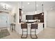 Modern kitchen with barstool seating at the countertop bar area, pendant lights, and dark wood cabinets at 892 Hubbard Loop, The Villages, FL 32163