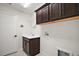 Laundry room with storage cabinets and utility sink, plus tile floors at 892 Hubbard Loop, The Villages, FL 32163
