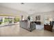 Bright living room featuring a comfortable gray sofa, tile floors, and sliding doors to a lanai at 892 Hubbard Loop, The Villages, FL 32163