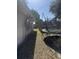 Long narrow side yard with trampoline and some grass and weeds at 916 Kentucky St, Haines City, FL 33844