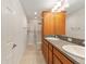 Bathroom featuring double sinks, wood cabinets, and a shower, offering a functional space at 9181 Se 166Th Sprung Ln, The Villages, FL 32162