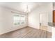 Dining area featuring wood-look floors, a modern chandelier, and a view of the front yard at 9181 Se 166Th Sprung Ln, The Villages, FL 32162
