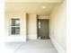 Covered entryway featuring a window, a concrete floor and a paneled front door at 9181 Se 166Th Sprung Ln, The Villages, FL 32162