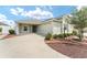 Home exterior featuring landscaped front yard, a concrete driveway and a two-car garage at 9181 Se 166Th Sprung Ln, The Villages, FL 32162