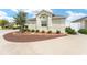 Well-maintained front yard features a decorative tree, stone accents, and tidy landscaping at 9181 Se 166Th Sprung Ln, The Villages, FL 32162