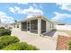 The house has a screened lanai, a concrete patio, and a well-maintained yard at 9181 Se 166Th Sprung Ln, The Villages, FL 32162