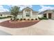 Landscaped front yard with a charming stone accent garden and lush greenery, with concrete driveways at 9181 Se 166Th Sprung Ln, The Villages, FL 32162