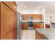 Well-equipped kitchen with stainless steel refrigerator, microwave, oven, and wooden cabinets at 9181 Se 166Th Sprung Ln, The Villages, FL 32162