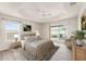 Staged main bedroom with tray ceiling, ceiling fan, access to the patio, and neutral decor at 9181 Se 166Th Sprung Ln, The Villages, FL 32162