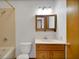 Bathroom featuring a tub and shower, vanity, mirror, and toilet at 9236 County Road 48, Yalaha, FL 34797