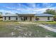 Charming single-story brick home with a metal roof and covered front porch with beautiful blue skies above at 9236 County Road 48, Yalaha, FL 34797