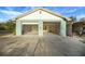 Two car garage features a wide driveway, an extra storage shed, and access to the backyard at 9236 County Road 48, Yalaha, FL 34797