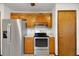 A close up of a kitchen area, showcasing stainless steel appliances and wood cabinets with decorative trim at 9236 County Road 48, Yalaha, FL 34797
