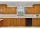 The kitchen showcases natural wood cabinets, laminate countertops, and stainless steel appliances, with a serene outdoor view at 9236 County Road 48, Yalaha, FL 34797