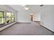 Spacious living room with neutral carpet, a ceiling fan, a view of the lawn and a view of the doorway at 9236 County Road 48, Yalaha, FL 34797