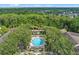 Aerial view of a complex with a pool and condos bordered by trees at 1021 Siena Park Blvd # 204, Kissimmee, FL 34747