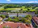 Aerial view of community featuring multiple buildings, lush landscaping, and nearby golf course at 1021 Siena Park Blvd # 204, Kissimmee, FL 34747