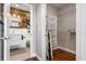 A contemporary bathroom features a textured vanity, wood wall, and a glimpse into a spacious walk-in closet with shelving at 1021 Siena Park Blvd # 204, Kissimmee, FL 34747