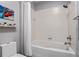 This bathroom features a white tub with shower and gray wall accents at 1021 Siena Park Blvd # 204, Kissimmee, FL 34747