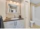 This bathroom features a sink with a wooden mirror and a white toilet and tub at 1021 Siena Park Blvd # 204, Kissimmee, FL 34747