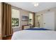 Bedroom featuring hardwood floors, with a TV, and a window view, plus a doorway to another room at 1021 Siena Park Blvd # 204, Kissimmee, FL 34747