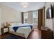 Inviting bedroom with rich hardwood floors, a castle wall decal, and abundant light from two windows at 1021 Siena Park Blvd # 204, Kissimmee, FL 34747