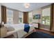 Bright bedroom with hardwood floors, three large windows, and a mounted TV, offering style and comfort at 1021 Siena Park Blvd # 204, Kissimmee, FL 34747