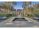 A serene community clubhouse and water feature create a welcoming atmosphere amidst mature trees at 1021 Siena Park Blvd # 204, Kissimmee, FL 34747