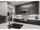 Modern kitchen with stainless steel appliances, dark cabinets, quartz countertops, and stylish faucet at 1021 Siena Park Blvd # 204, Kissimmee, FL 34747