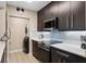 Modern kitchen with stainless steel appliances, quartz countertops, and stacked washer and dryer at 1021 Siena Park Blvd # 204, Kissimmee, FL 34747