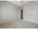 Bedroom features neutral carpeting, a ceiling fan, and closet space, with a doorway leading to another area at 1027 Timbervale Trl, Clermont, FL 34715