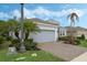 Well-maintained home with a brick paver driveway, lovely landscaping, and a two-car gray garage door at 1027 Timbervale Trl, Clermont, FL 34715