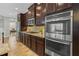Well-equipped kitchen with stainless steel appliances, granite countertops, and dark wood cabinetry at 1027 Timbervale Trl, Clermont, FL 34715