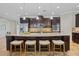 Spacious kitchen island with seating, granite counters, dark cabinets, and stainless steel appliances at 1027 Timbervale Trl, Clermont, FL 34715