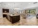 Open-concept kitchen with dark wood cabinetry, granite countertops, an island with seating, and stainless appliances at 1027 Timbervale Trl, Clermont, FL 34715