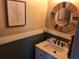Stylish half bathroom featuring vanity, round mirror, and modern fixtures at 1033 N Jacks Lake Rd, Clermont, FL 34711