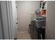 Functional laundry room with machines, shelving, and storage for cleaning supplies at 1033 N Jacks Lake Rd, Clermont, FL 34711