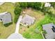 Aerial perspective of a tan home on a large lot, surrounded by lush landscaping and neighboring houses at 10465 Se 41St Ter, Belleview, FL 34420